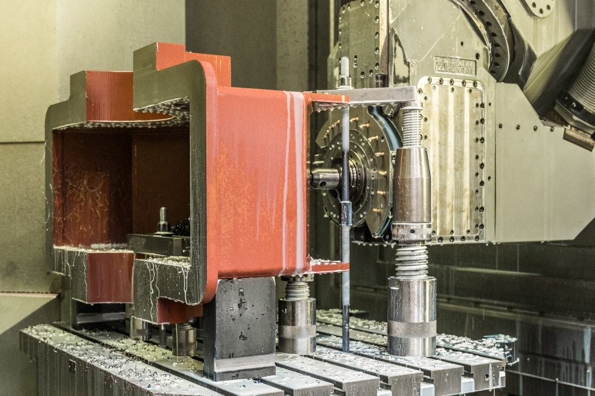 Bloco de metal numa fresadora CNC durante a usinagem.