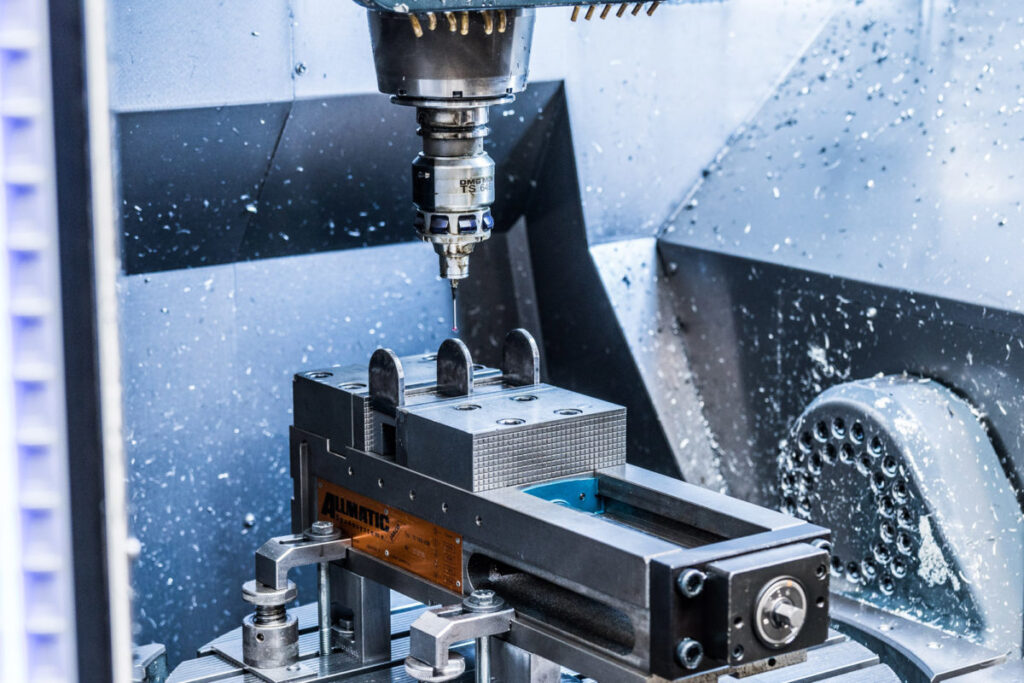 USINAGEM CNC: Uma fresadora usina um bloco de metal numa oficina.