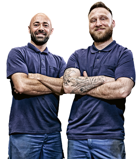 Dois homens com camisas polo azuis, de braços cruzados.