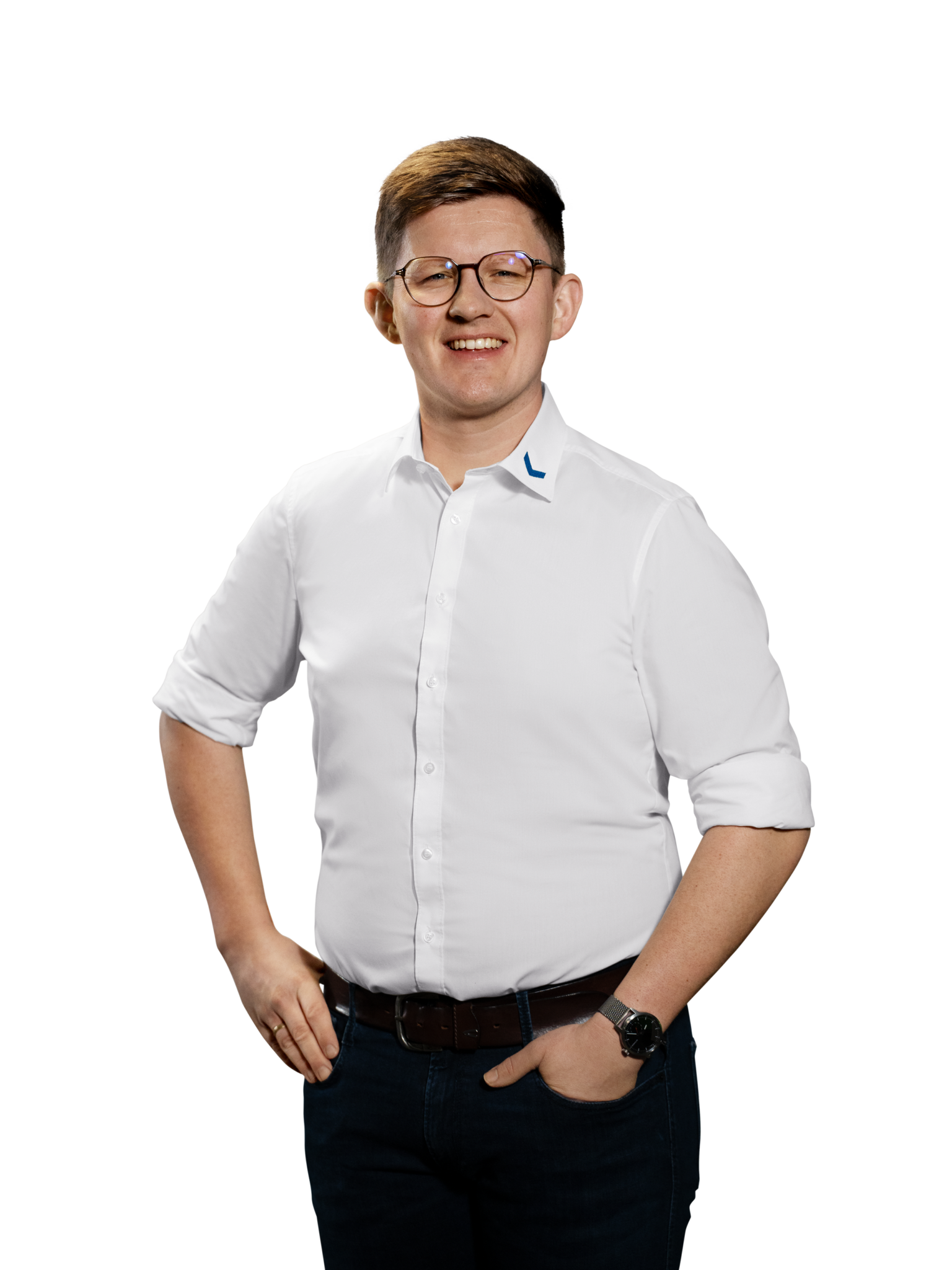 Mann mit Brille in weißem Hemd und Jeans lächelt in die Kamera.