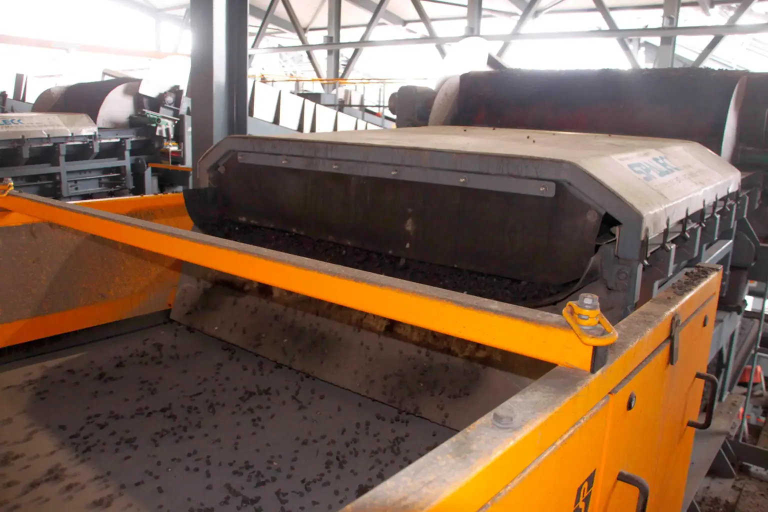 Calha transportadora oscilante autolimpante SPALECK ActiveCLEAN numa instalação de tratamento de escórias, durante o transporte da escória MV para um separador de correntes de Foucault (NES)
