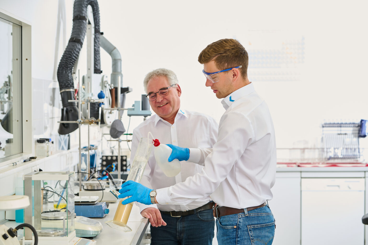 Dois homens num laboratório, a trabalhar num projeto de tratamento de água.
