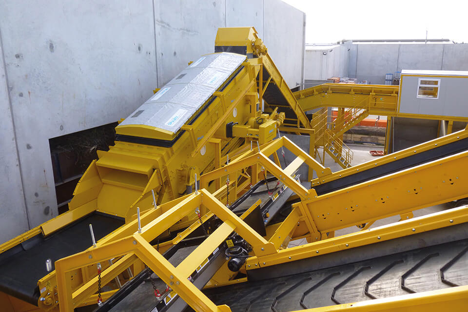 Instalação de reciclagem amarela para resíduos mistos da construção, equipada com correias transportadoras.