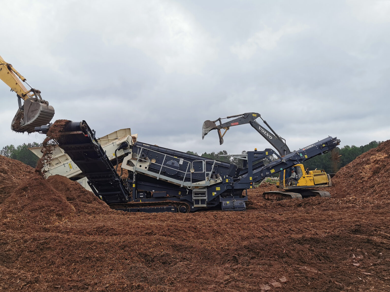 Instalações de crivagem móveis em funcionamento no processamento de materiais num estaleiro de construção.