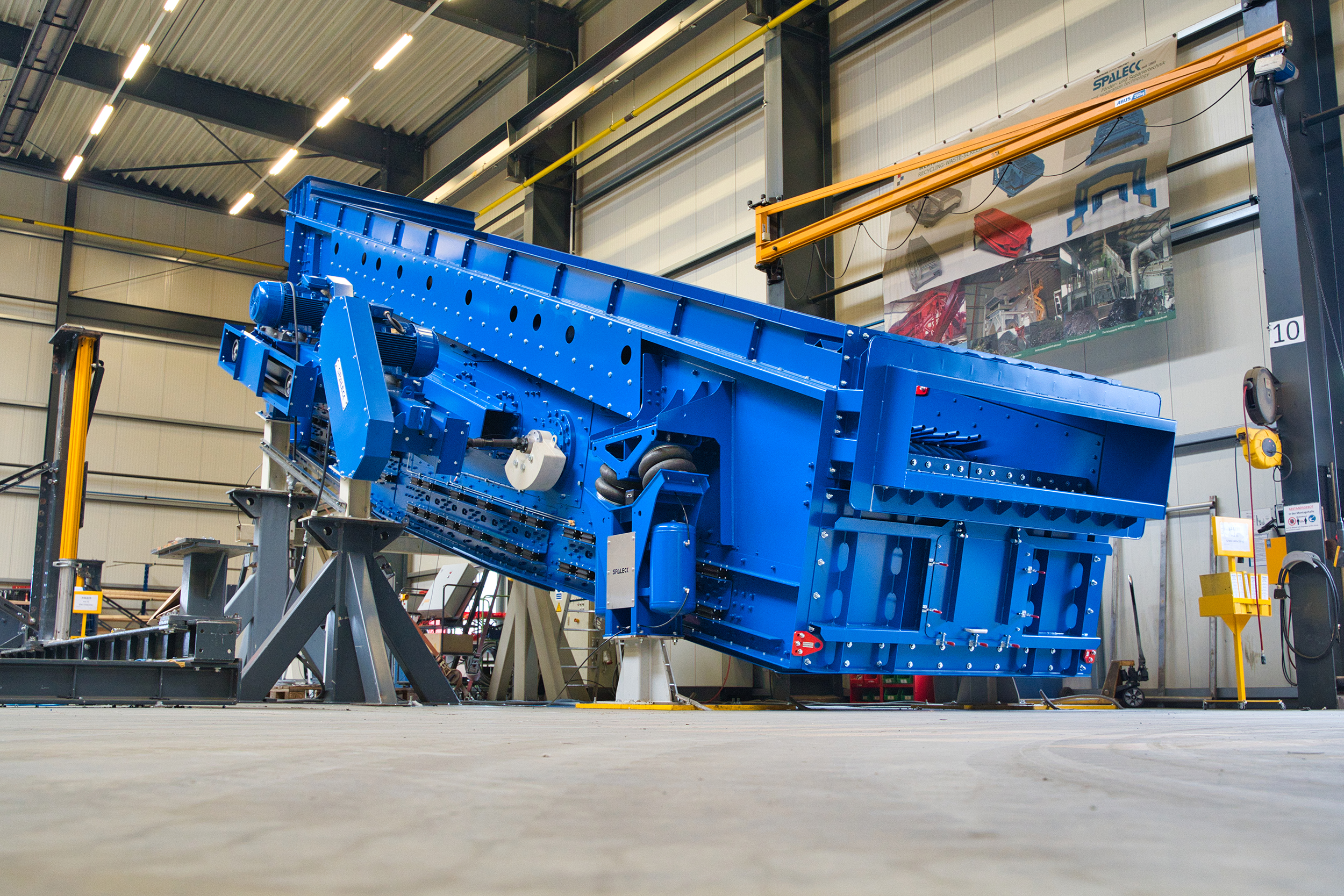 Máquina de peneiramento azul num pavilhão industrial, formação de mecânico industrial.