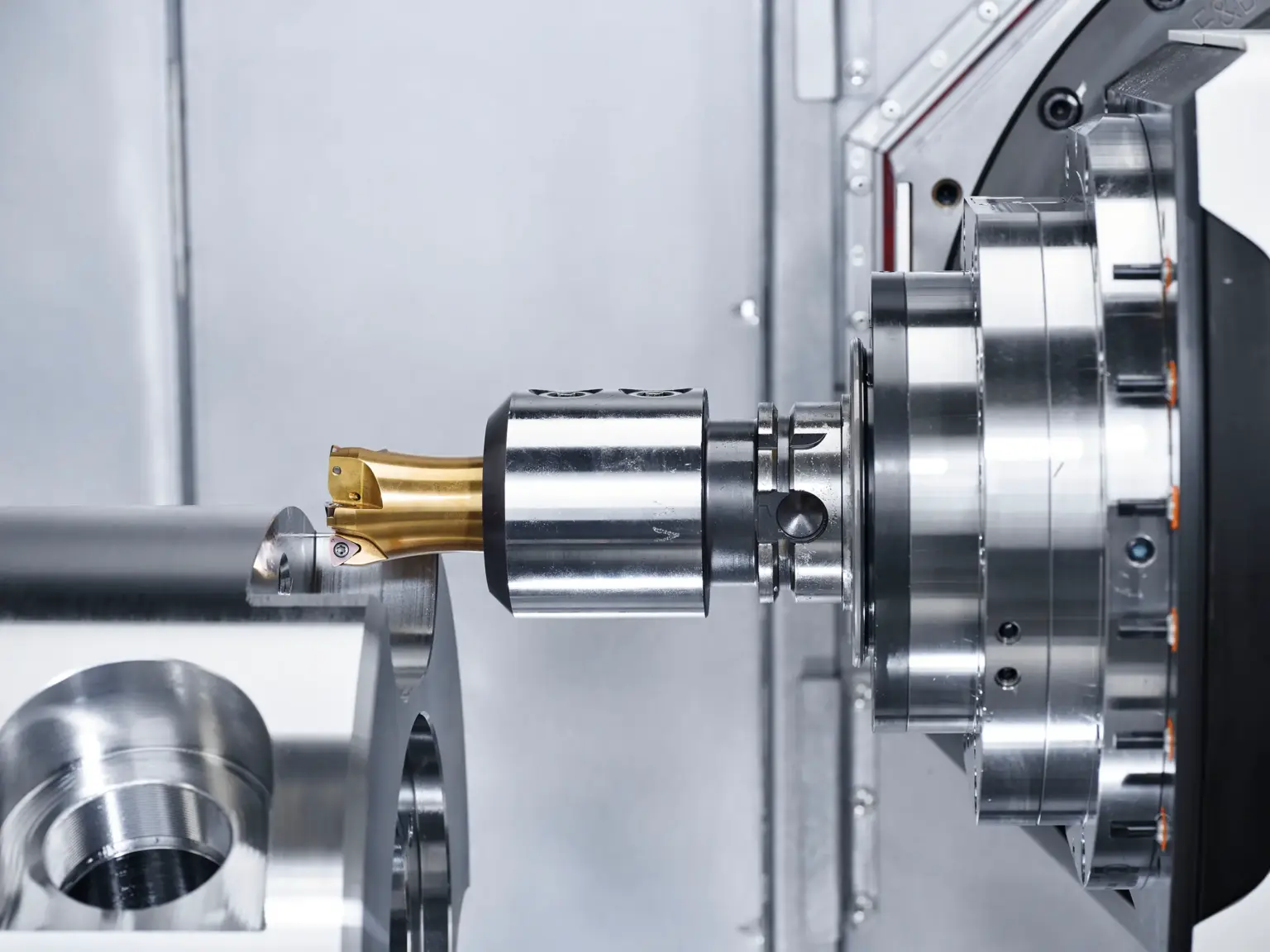 Máquina CNC usina peças metálicas, com destaque para peças torneadas de precisão.