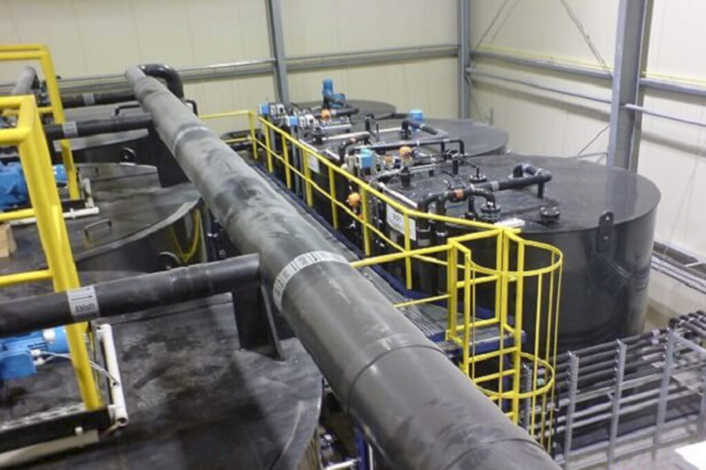 Instalação industrial para o tratamento de água de circulação, com grandes tanques e condutas.