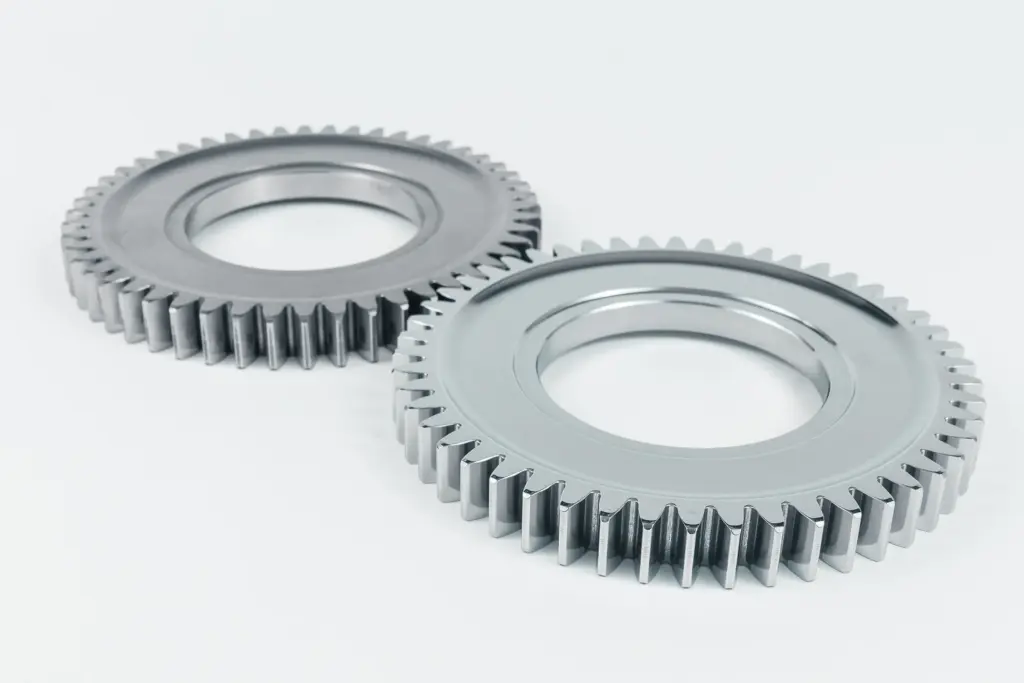 Duas rodas dentadas brilhantes sobre um fundo branco.