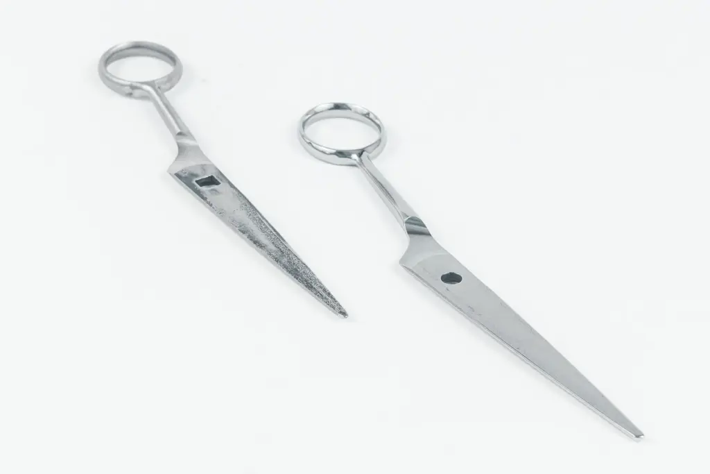 Duas ferramentas de metal polido com pega em forma de anel sobre um fundo branco.