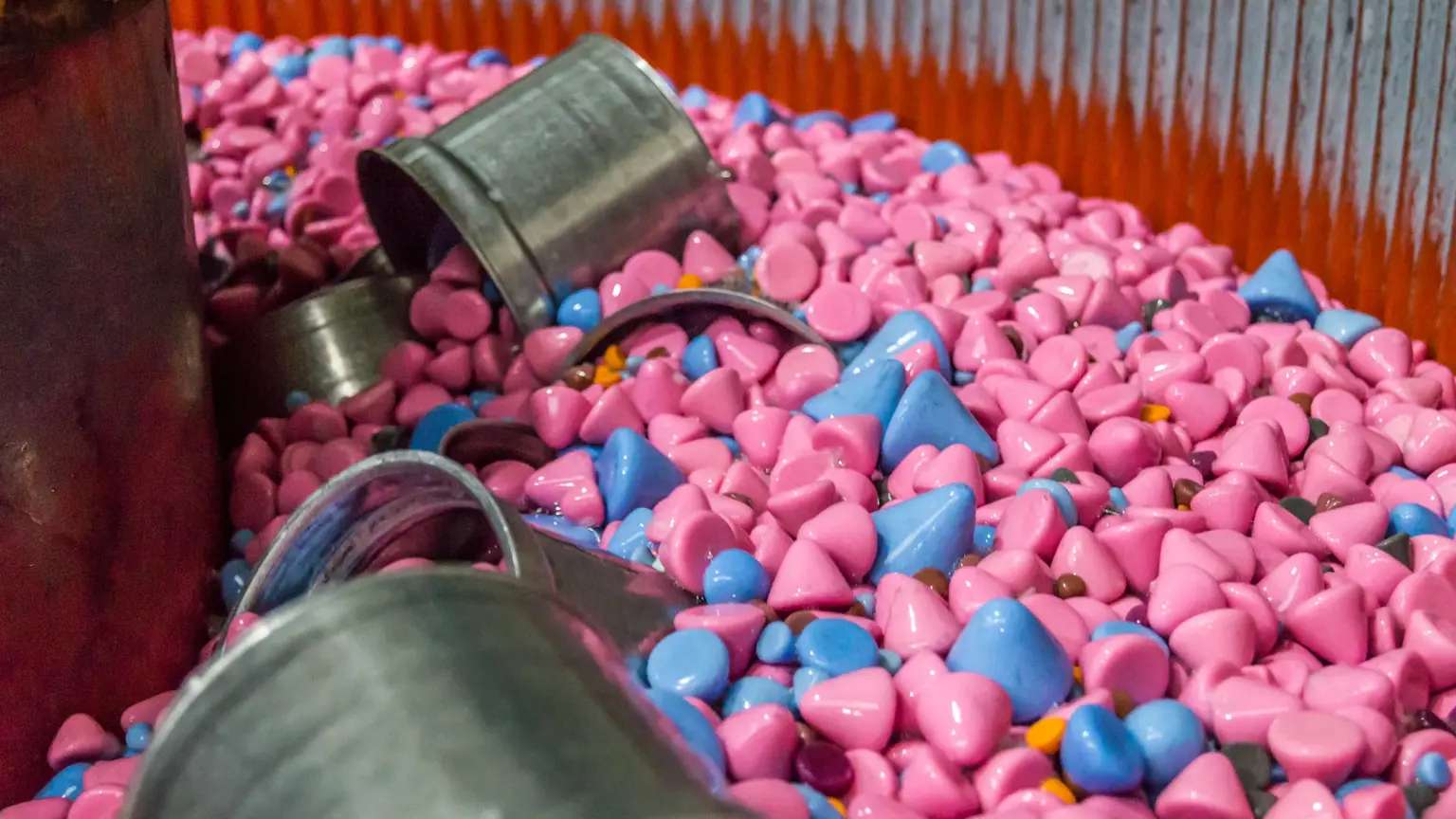 Peças metálicas e corpos abrasivos durante o polimento por deslizamento numa máquina.