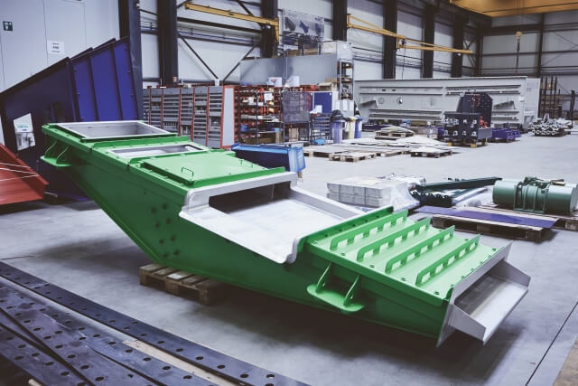 Calha transportadora oscilante da SPALECK, na versão parcialmente coberta, para a utilização de um íman de banda