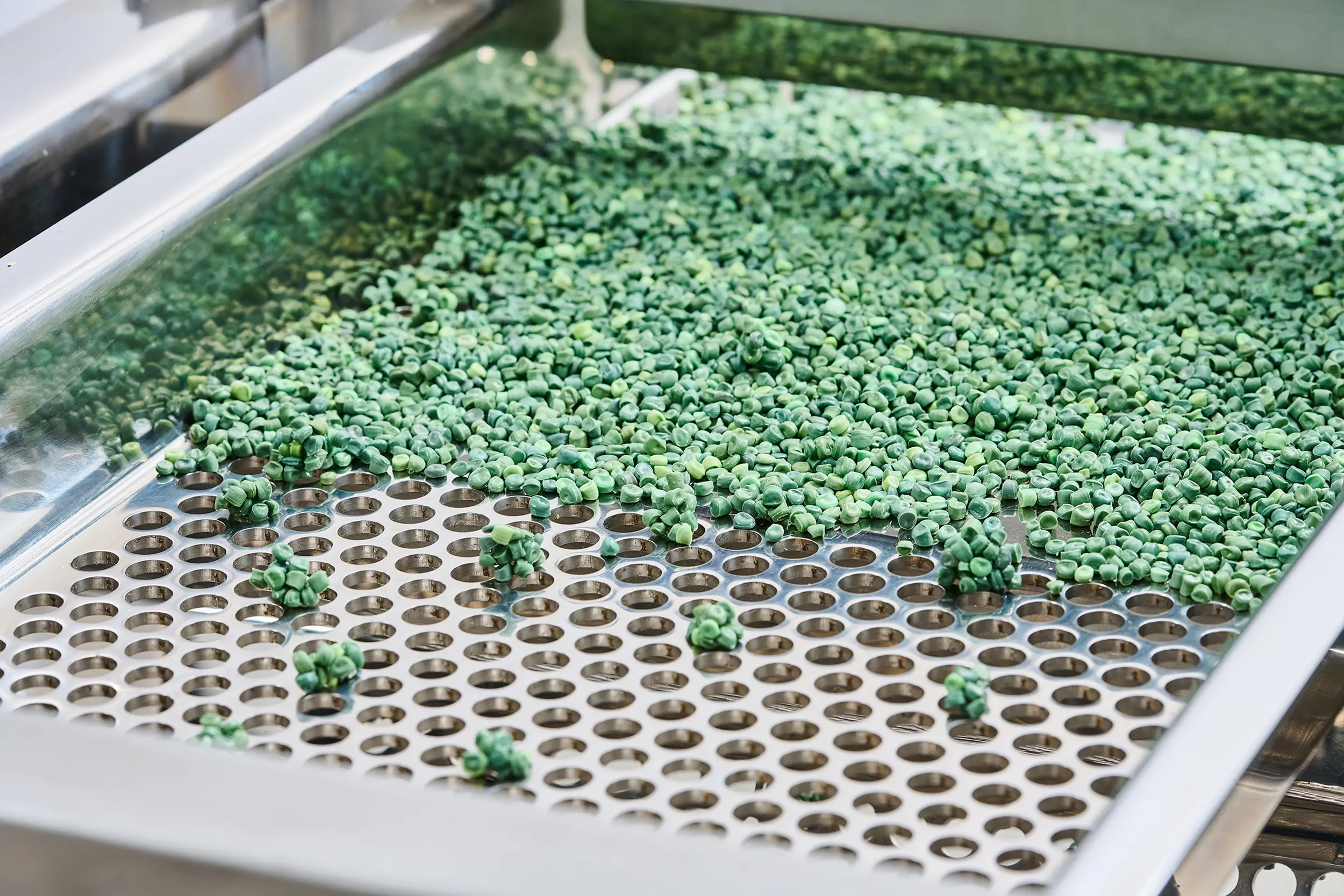 Granulados verdes numa máquina de peneiramento de granulados, que permite uma separação precisa.