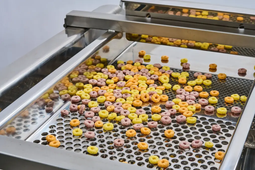 Fotografia detalhada do tabuleiro de uma máquina de peneirar para produtos alimentares
