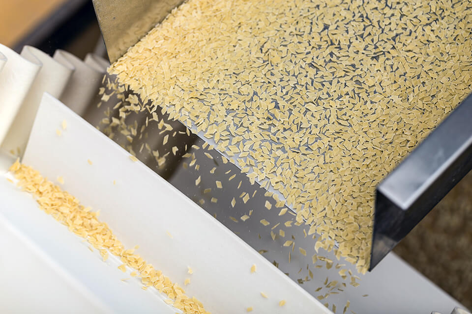 Alimentação e dosagem com uma calha vibratória na produção alimentar