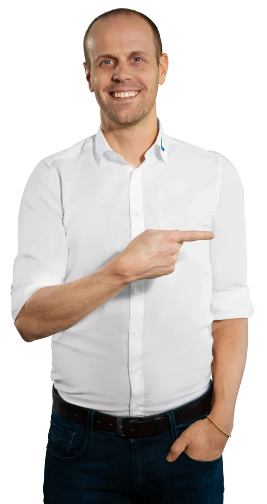 Um homem de camisa branca aponta para a direita, no contexto da reciclagem de resíduos eletrónicos da «Immark».