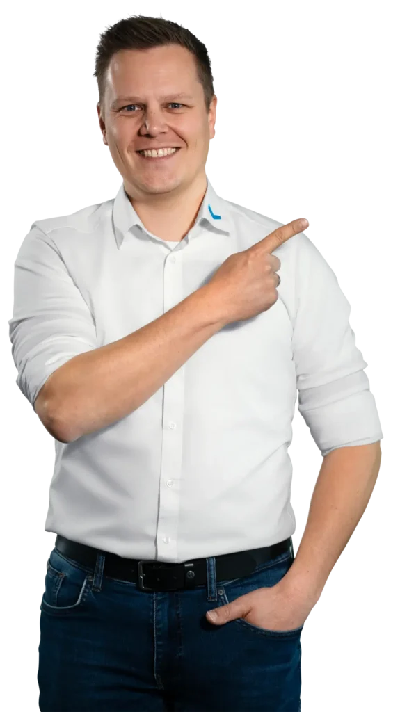 Um homem de camisa branca aponta para a direita, sorrindo.