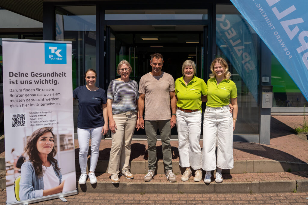 Fotografia de grupo no Dia da Saúde do Spaleck com Marina Pawlak, Marlis Spaleck, Andreas Niedrig, Gabi Mumbek e Hanna Hitpaß em frente ao Centro de Saúde Spaleck